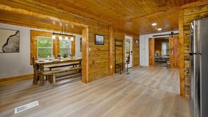 A wooden interior with a dining area, a refrigerator, and a bench. - Outdoor pvt pool! hot tub, deck, RIP Dolly! (Sevierville)