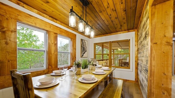A wooden dining table set with plates, glasses, and a centerpiece. - Outdoor pvt pool! hot tub, deck, RIP Dolly! (Sevierville)