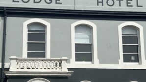 Un bâtiment sur lequel on peut lire l’inscription « Lodge Hotel » au-dessus de trois fenêtres en arc de cercle.