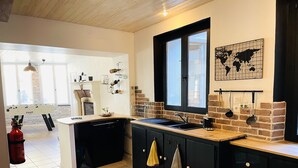 Een moderne keuken met een zwart aanrecht, een raam en een wereldkaart aan de muur.