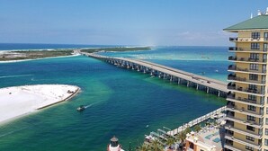 A coastal hotel with a pier extending into turquoise waters, a beach, and a view of the ocean. - GORGEOUS BEACHFRONT VIEWS!! FREE BEACH SET UP, PRIVATE BEACH, POOL, SPA, AND GYM (Miramar Beach)