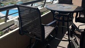 A balcony with a view of the beach and ocean, featuring wicker chairs and a round table. - GORGEOUS BEACHFRONT VIEWS!! FREE BEACH SET UP, PRIVATE BEACH, POOL, SPA, AND GYM (Miramar Beach)