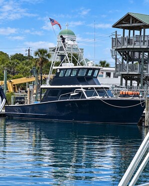 Un barco grande amarrado en un muelle, cerca hay una estructura cubierta.