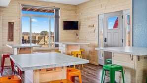 Una cocina moderna con paredes de madera, una isla grande y un televisor sobre la isla.