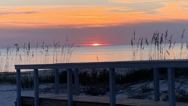 A wooden bench overlooking a beach at sunset. - 5 minute walk to beach - come relax, enjoy family time and even fish. (Port St. Joe)