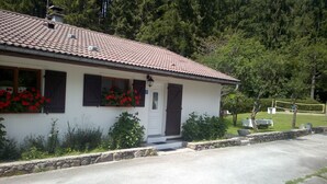 Ein einstöckiges Gebäude mit Ziegeldach, einer Haustür und Fenstern mit Fensterläden.
