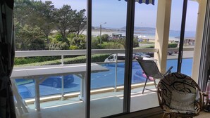 Une chambre avec vue sur une piscine et un parking.