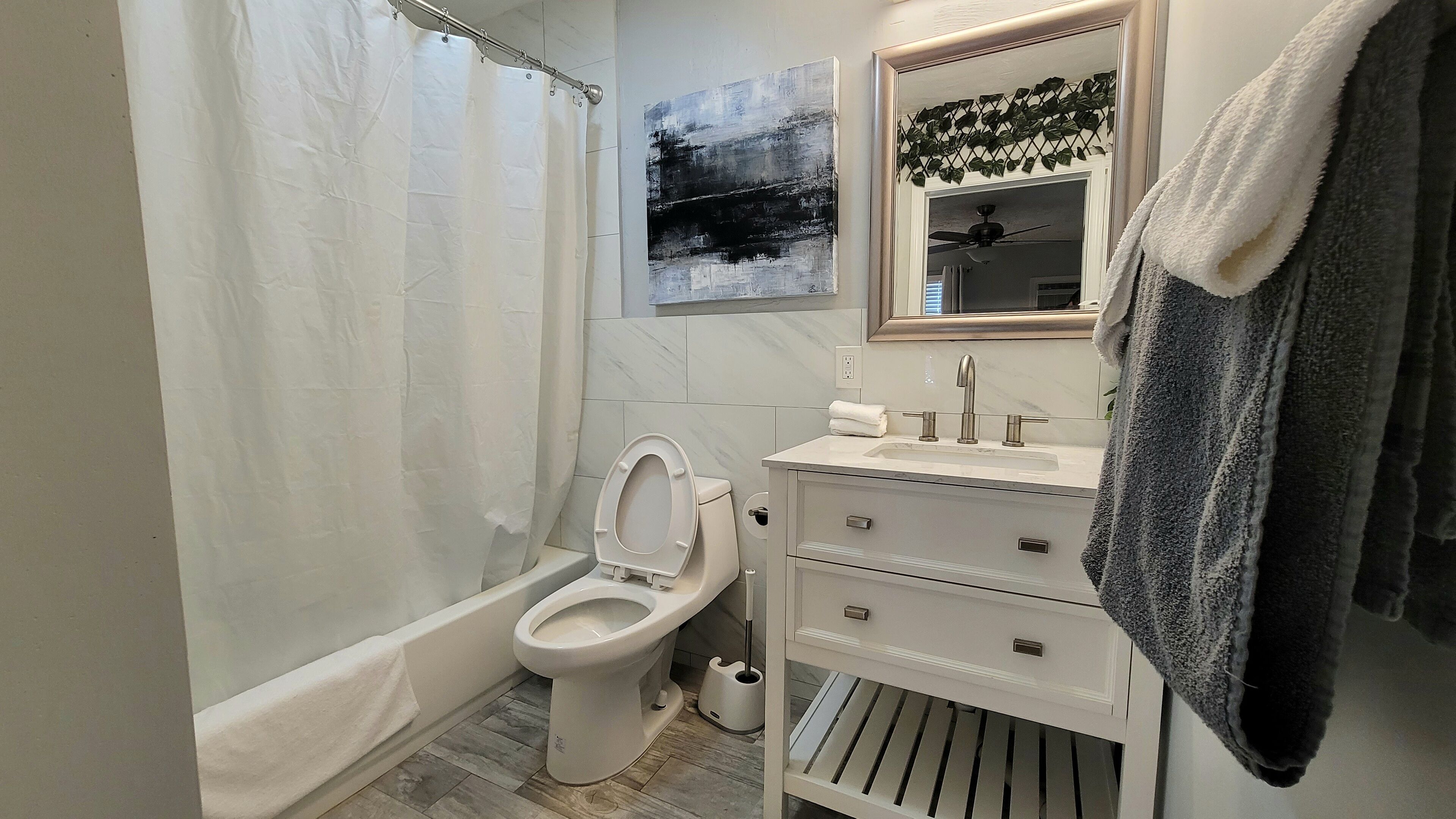 A bathroom with a toilet, sink, and shower curtain.