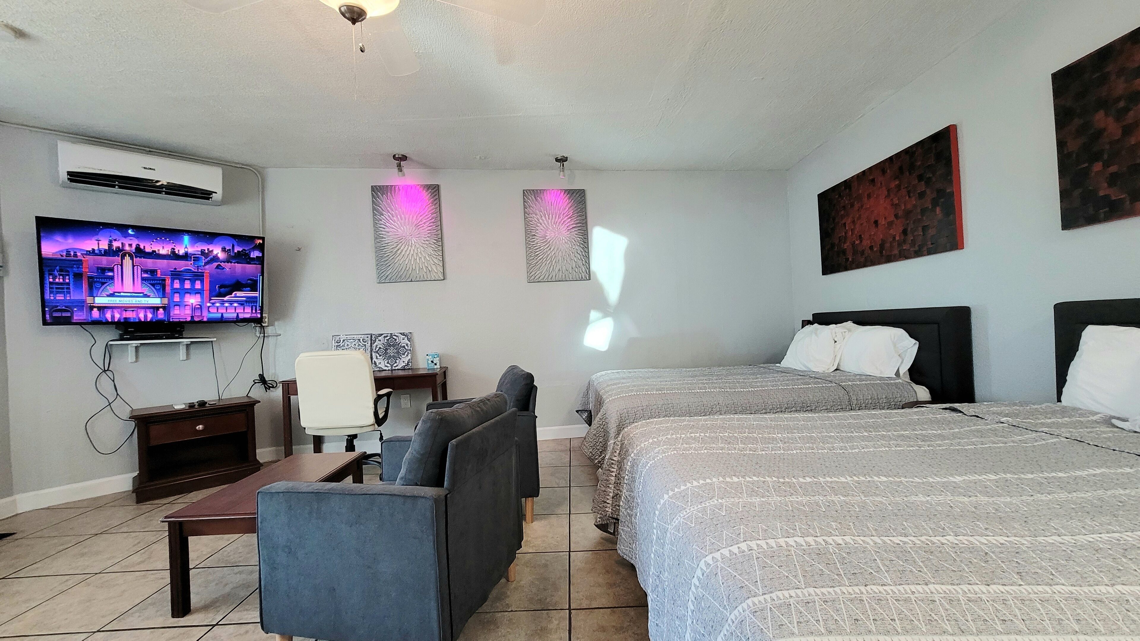 Ett hotellrum med två sängar, en TV, ett skrivbord och en stol.