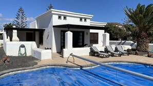 A modern house with a swimming pool, outdoor seating, and a pergola. - Casa Sophia (Playa Blanca)