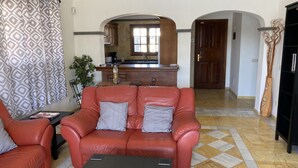 A living room with a red sofa, a small table, and a patterned curtain. - Casa Sophia (Playa Blanca)