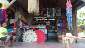 A rustic shop with handmade crafts, textiles, and traditional items displayed outside.