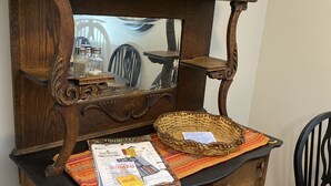 A wooden dresser with a mirror, a woven basket, and various glassware. - Fireside Ranch of Romeo (bruce twp)