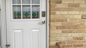 A white door with a glass panel and a number "3" on it, a keypad lock, and a wall-mounted light fixture. - Fireside Ranch of Romeo (bruce twp)