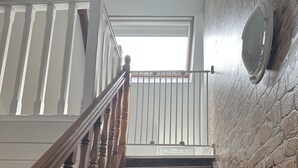 Una escalera de madera con barandillas blancas que lleva a una plataforma.