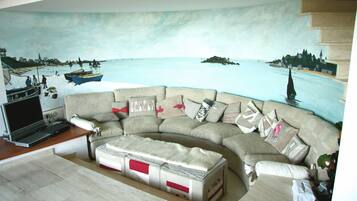 Télévision, cheminée, table de tennis de table, livres