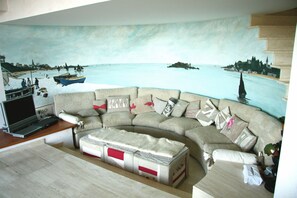 Télévision, cheminée, table de tennis de table, livres