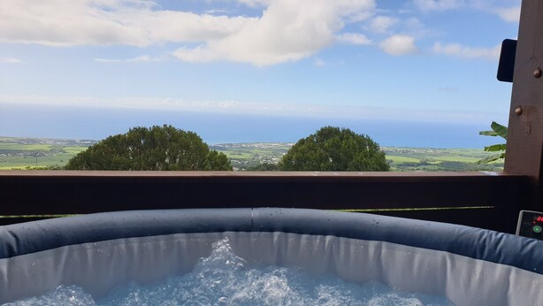Ein Whirlpool mit Blick auf den Ozean und die Hügel.