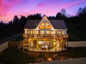 A two-story house with a balcony, a deck, and a fire pit in the yard. - The Nordic Chalet : Theatre Room, Game Room, Hot tub, Fire Pit, Location (Sevierville)