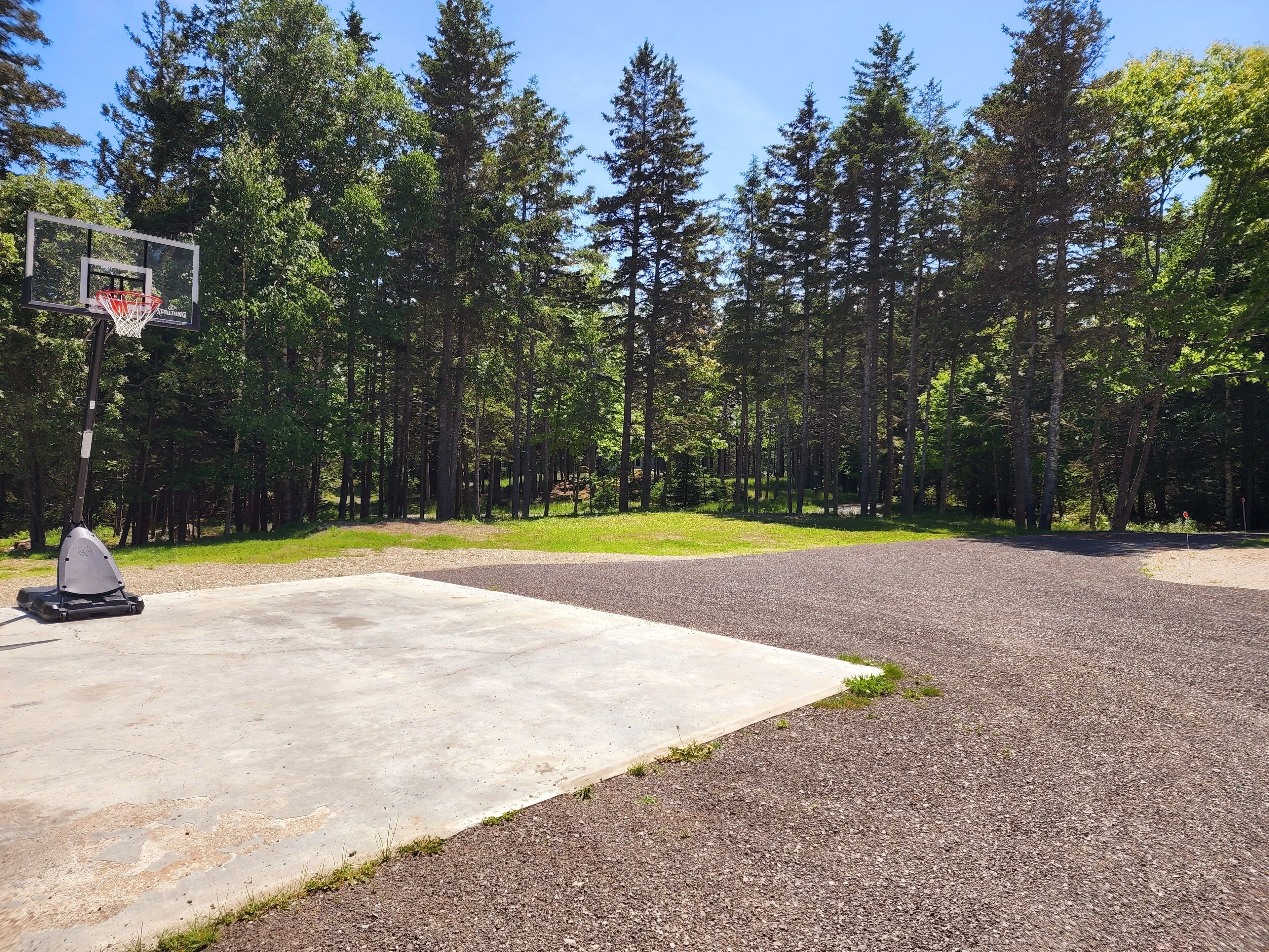 Uma quadra de basquete com uma cesta e uma bicicleta ergométrica.