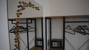 A room with a mirrored wall, wooden shelves, and two electronic devices on the shelves.