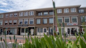 A multi-story building with a garage service on the ground floor and a business named "PROFILE" on the second floor.