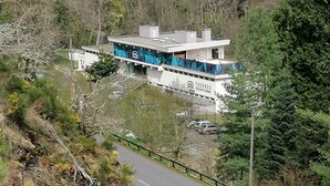 A modern building with a sign reading "THERMES" on a hillside with a winding road. - LA CABANE AUX ECREVISSES- FEET IN THE WATER (Châteauneuf-les-Bains)