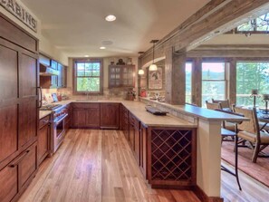 Une cuisine spacieuse avec des meubles en bois, un grand îlot central et un meuble à vin.