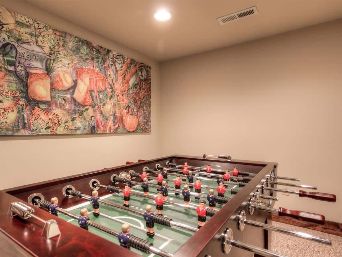 Une table de baby-foot dans une pièce où est accrochée une grande peinture abstraite au mur.