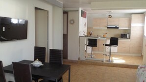 A compact living space with a dining area, kitchenette, and a TV mounted on the wall. - House with pool in Le Pradet quiet location  (Le Pradet)