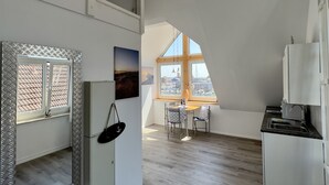 Een ruime keuken met een eethoek, een hoge plafond en uitzicht op het buiten.