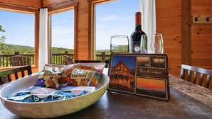 A wooden cabin with a table featuring a bowl of snacks, a bottle of wine, a glass, and a welcome sign. - Cascading View Lodge♡ Mtn Views, hot tub, fire pit, < 20 min from Blue Ridge (Blue Ridge)