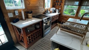 Une cuisine avec des murs en bois, une grande fenêtre et un meuble-bar intégré.