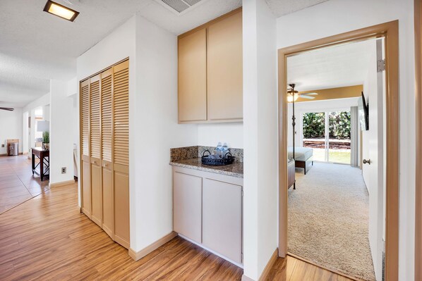 A modern kitchen with wooden cabinets, a granite countertop, and a view to the backyard.