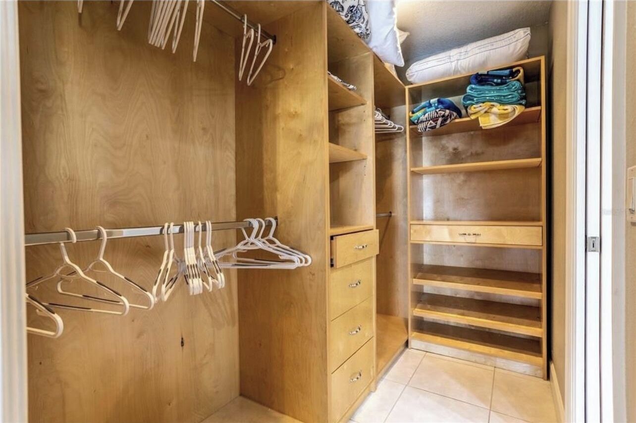 A wooden closet with hanging space and drawers.