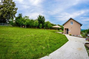A single-story building with a flat roof, a concrete pathway leading to the entrance, and a well-maintained grassy lawn.