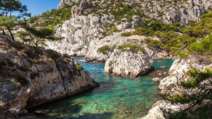 A rocky coastal landscape with clear turquoise water, rugged cliffs, and sparse vegetation. - Ideal Holiday Home for the 2024 Olympics Games in Marseille: Comfort & Proximity (Marseille)