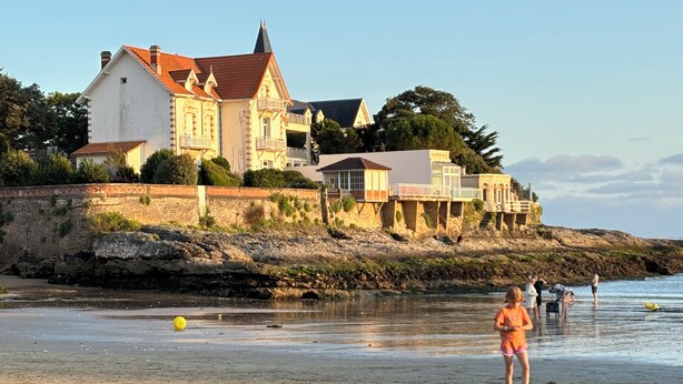 A coastal building with multiple levels and balconies, situated on a rocky shoreline with a beach in the foreground. - Renovated house with garden - 3 min walk from Le Bureau and Nauzan beaches (Saint-Palais-sur-Mer)
