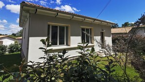 A single-story house with a tiled roof, two windows with shutters, and a small porch area. - Renovated house with garden - 3 min walk from Le Bureau and Nauzan beaches (Saint-Palais-sur-Mer)