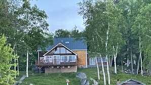 A lakeside cabin with a deck, a small shed, and a dock. - Private Lakefront Gem Within Minutes of Baxter State Park (Millinocket)