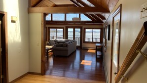 A spacious living area with a wooden ceiling and large windows overlooking a body of water. - Private Lakefront Gem Within Minutes of Baxter State Park (Millinocket)