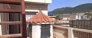 Enjoy the view from this balcony with a traditional tiled roof, metal railing, and decorative window.