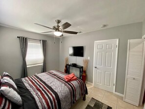 Cozy retreat with a single bed, ceiling fan, flat-screen TV, and closet.