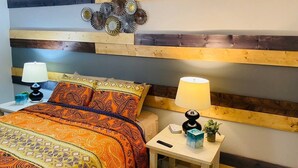 Ein Schlafzimmer mit einem Bett, zwei Nachttischen und einer Wand mit horizontalen Holzbalken.