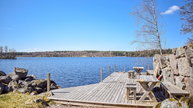 A wooden dock extending into a calm lake with a clear sky. - Gorgeous home in åryd with kitchen (Åryd)