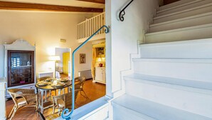 A staircase with white steps and a blue handrail leading to a second-floor landing.