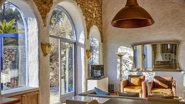 A spacious living area with a large dining table, comfortable seating, a television, and a view of the outdoors through large windows. - Casa Azul  at Masia Nur Sitges (Adults only 18+) (Canyelles)