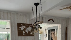 Una cocina moderna con una isla grande, armarios de madera y una lámpara colgante.