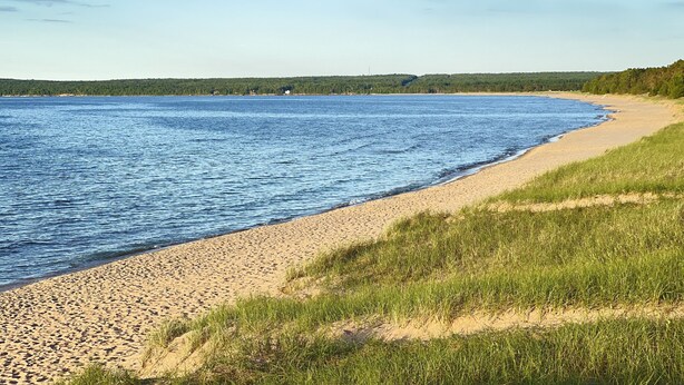 A beach with a sandy shore and a clear blue sky. -  Modern Cabin to relax and unwind  (Au train)