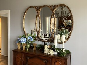 A wooden dresser with a large ornate mirror, a small statue, and decorative items. - 3 bedroom 2 bath Historic Home (Summit)